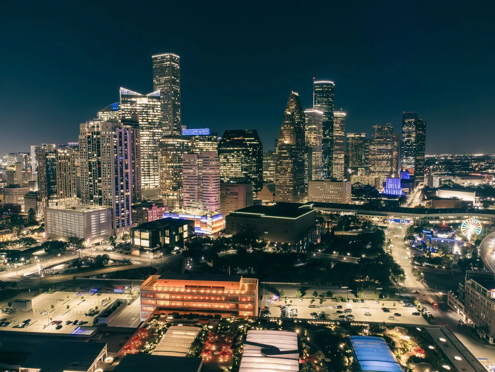 Stunning aerial view of a city skyline illuminated at night, showcasing modern architecture.